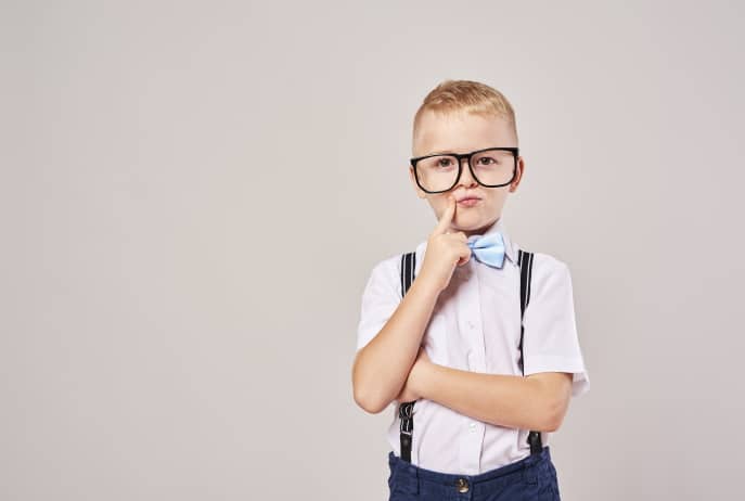 Elementary student with hand on chin thinking at studio shot